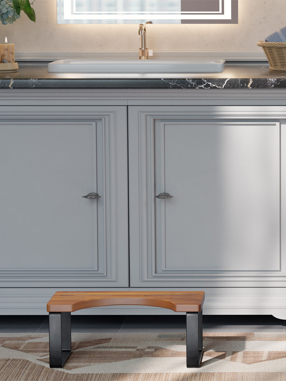 Wooden stool in front of gray cabinets with a marble countertop.