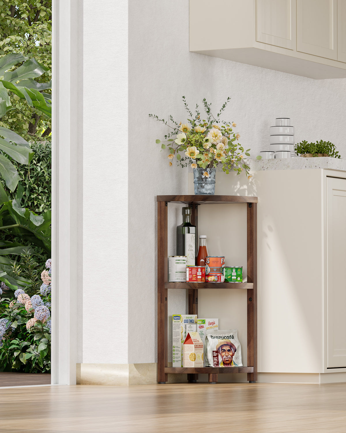 A three-tier wooden kitchen shelf with a dark brown finish, styled with various food items, a vase of flowers, and a small plant, set against a white kitchen wall.