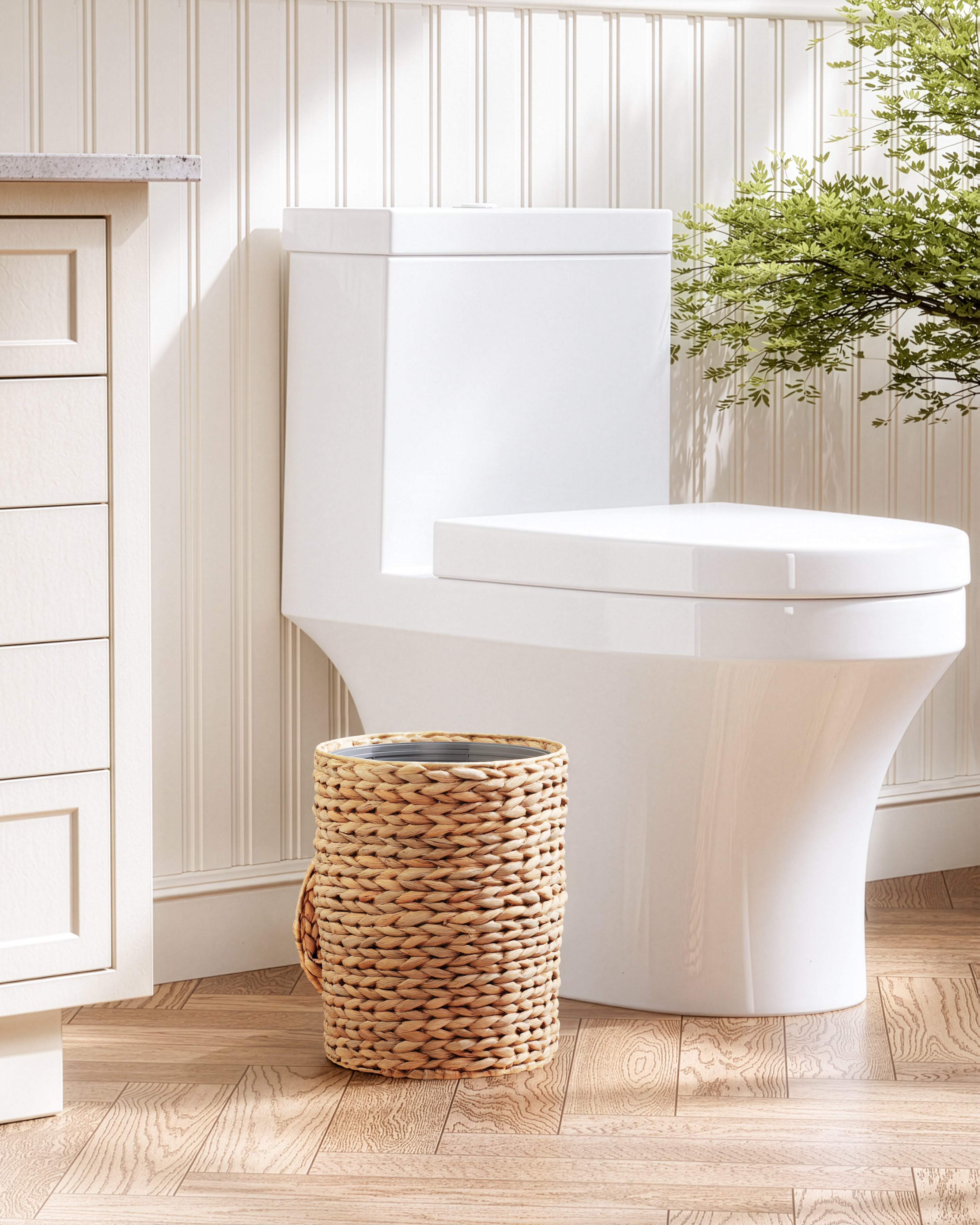 White toilet in a bathroom with a woven basket and a plant
