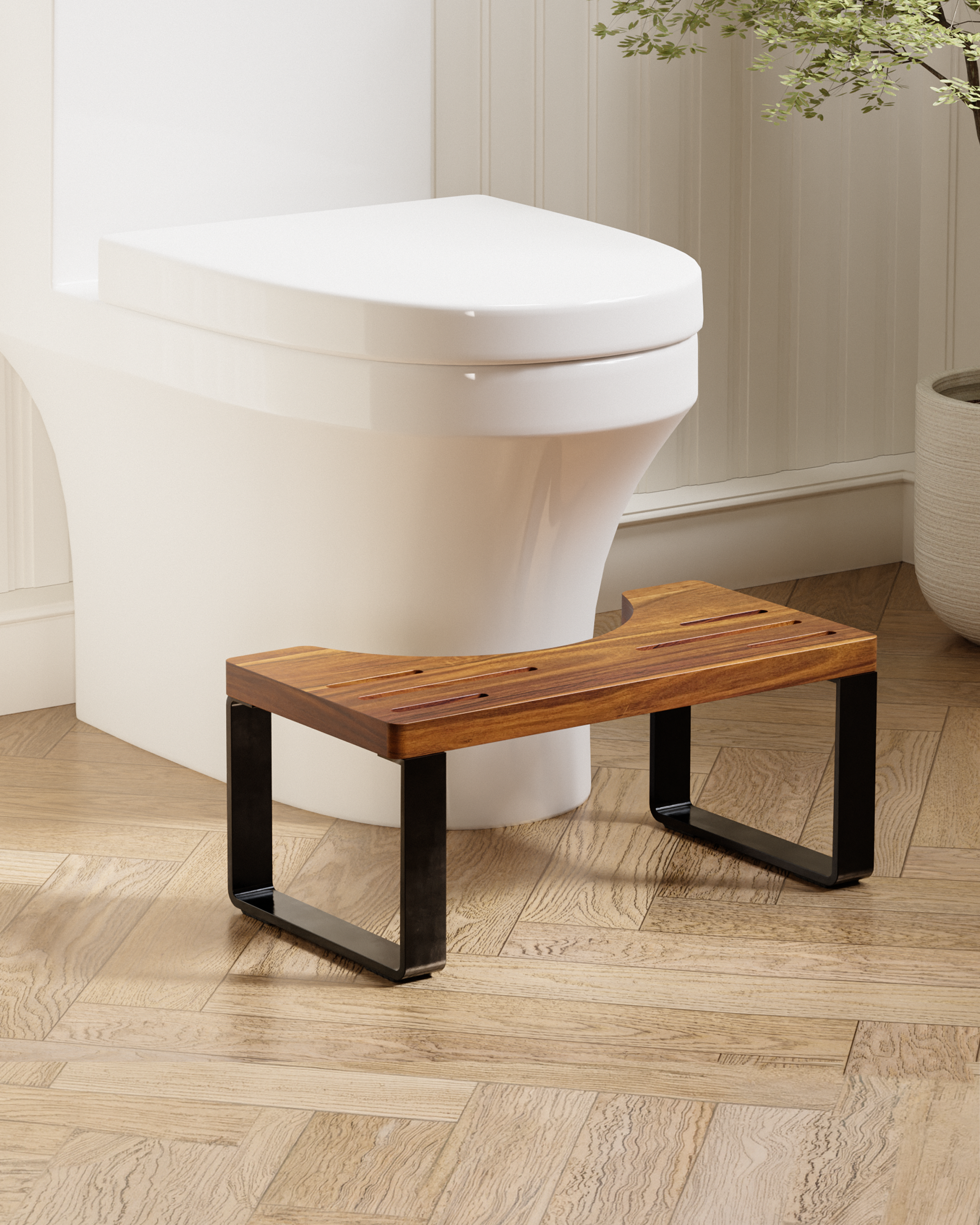 A wooden toilet step stool with black metal legs, positioned in front of a white toilet on a light wood herringbone floor.