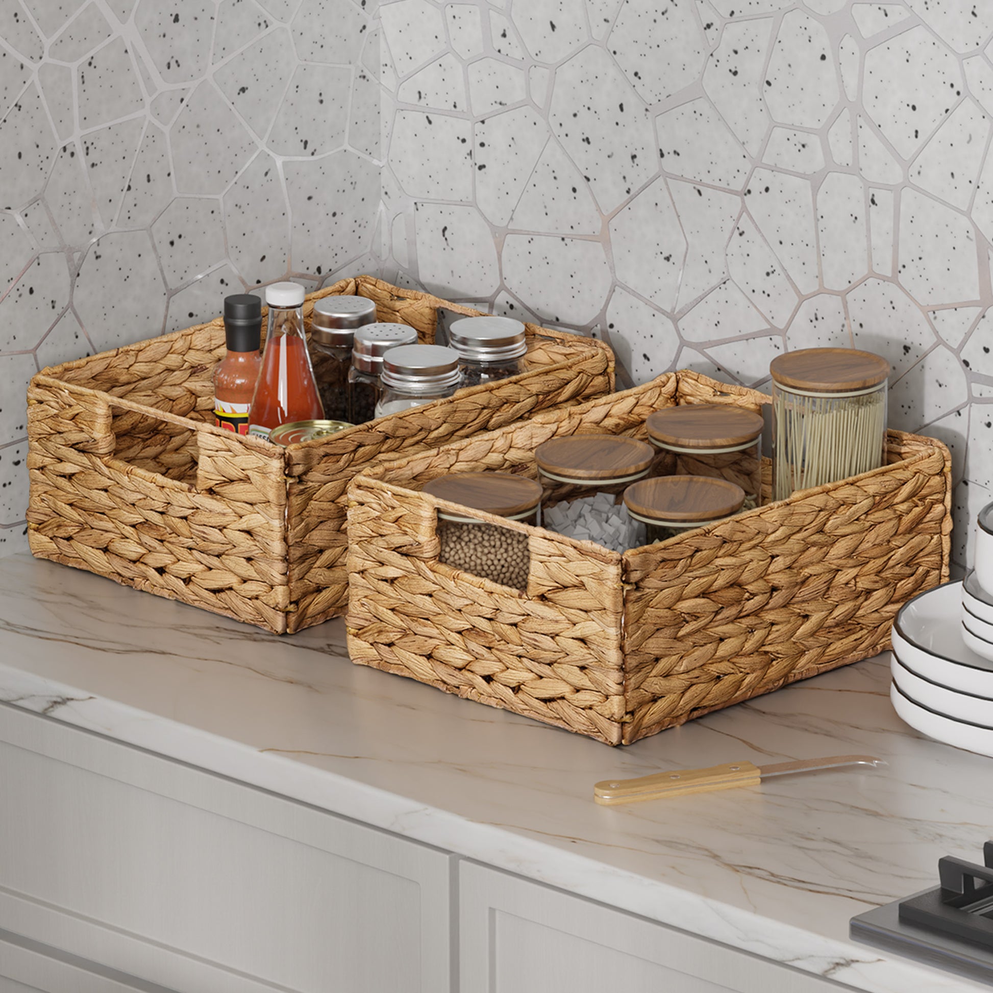 Woven baskets on a kitchen counter with jars and a tiled wall background