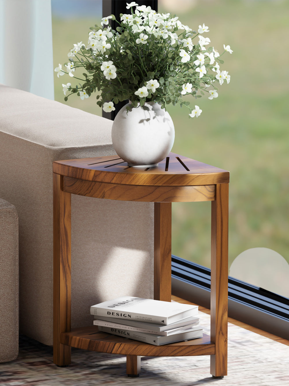 Wooden side table with a vase of white flowers and books on a blurred outdoor background