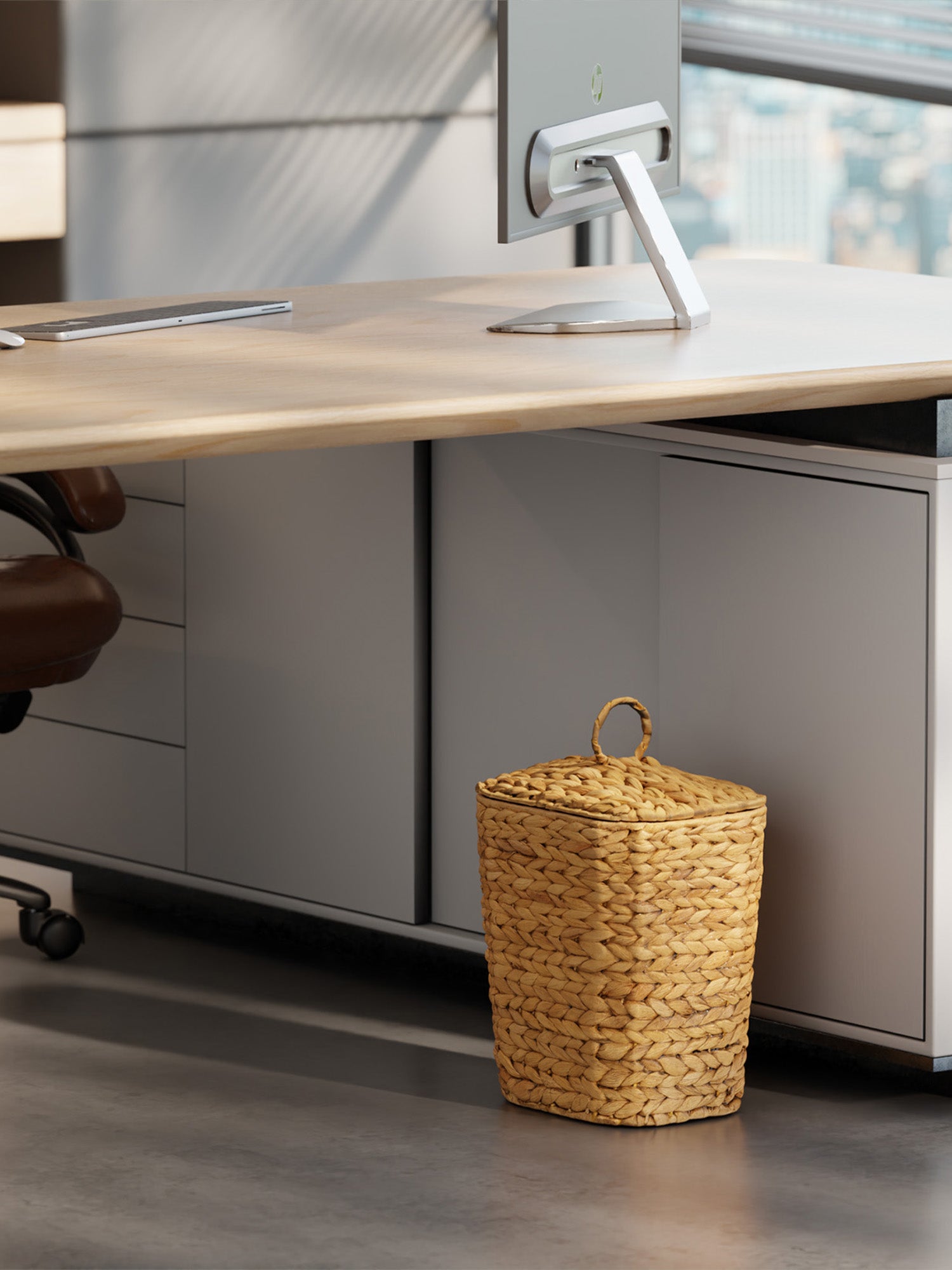 Wicker trash bin under a desk in an office setting